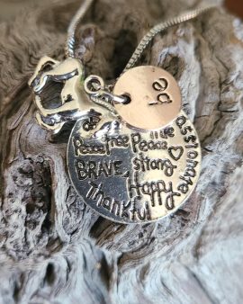 Inspirational Charm Necklace that has one small charm with the word "be" and a larger charm with more words to follow, such as: peace, free, brave, strong, happy, thankful.