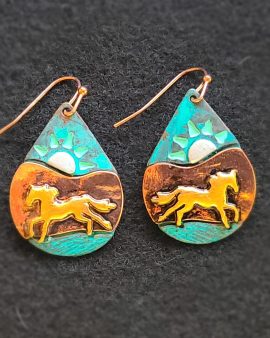 Metallic teardrop shaped earrings depicting a bright orange horse running across turquoise ground with darker-tinted mountain slopes behind them, a turquoise sky, and bright white sun.